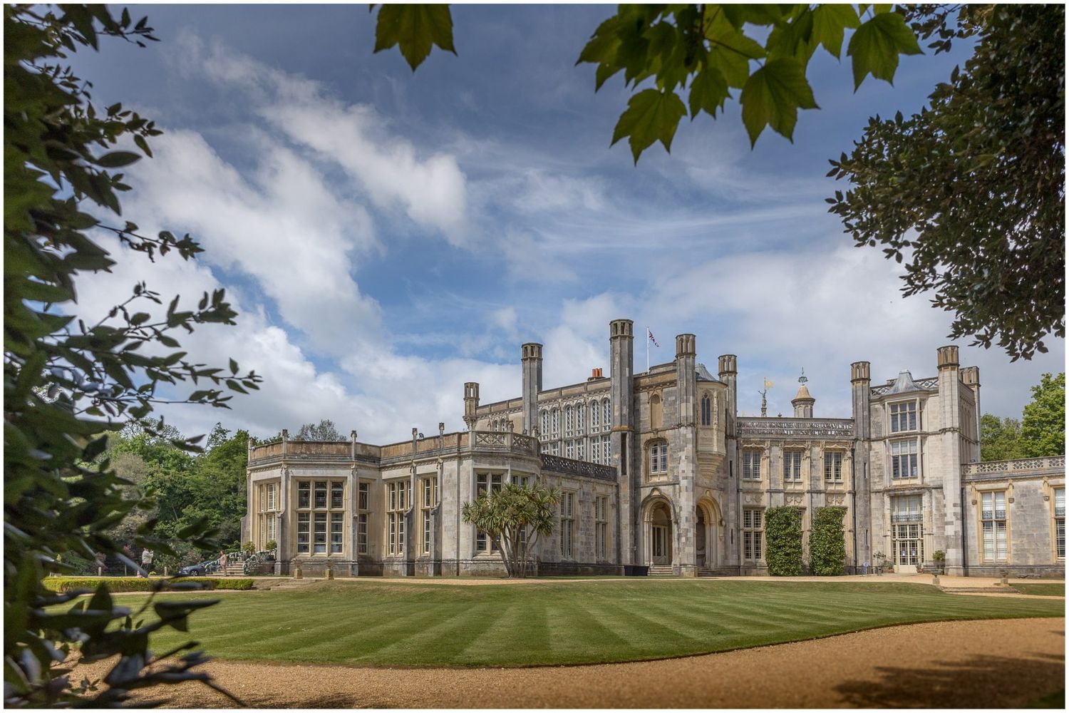 Panoramic view of a grand historic mansion with Gothic architecture under blue skies.