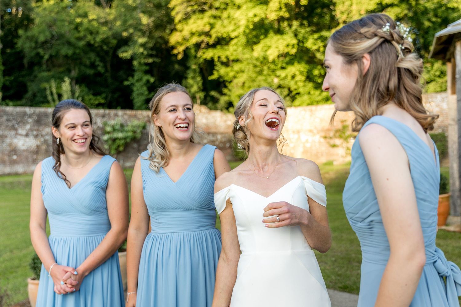 Joyful moment captured during an outdoor wedding with attendants in light blue dresses.