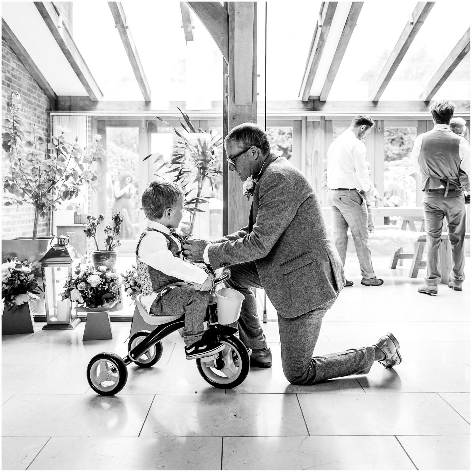 Black and white sequence showing someone assembling or working on a bicycle in an indoor space.