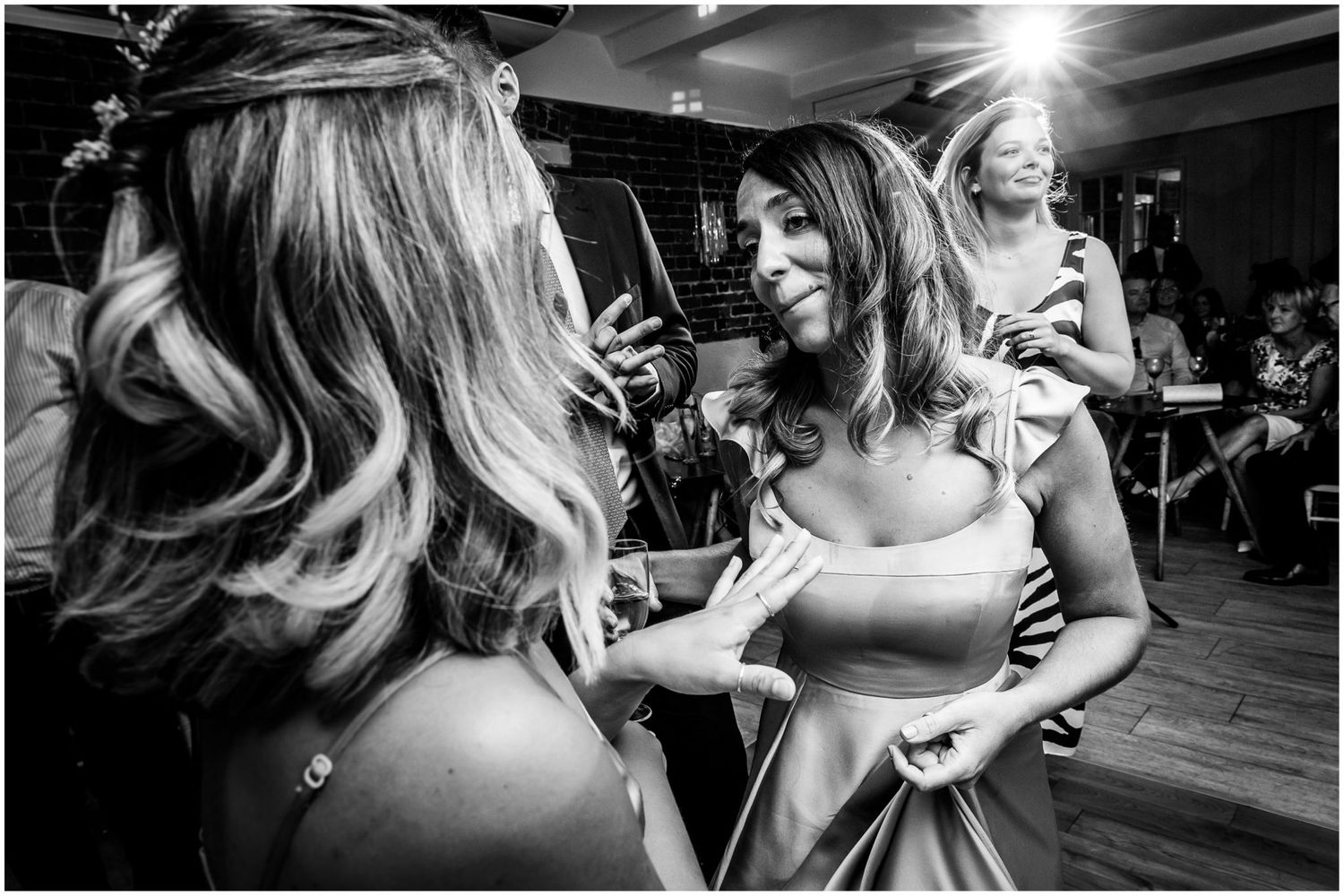 Black and white panorama of a lively wedding reception dance floor.