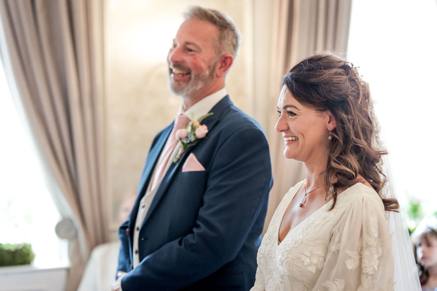 Joyful moment captured during wedding ceremony in bright indoor setting.