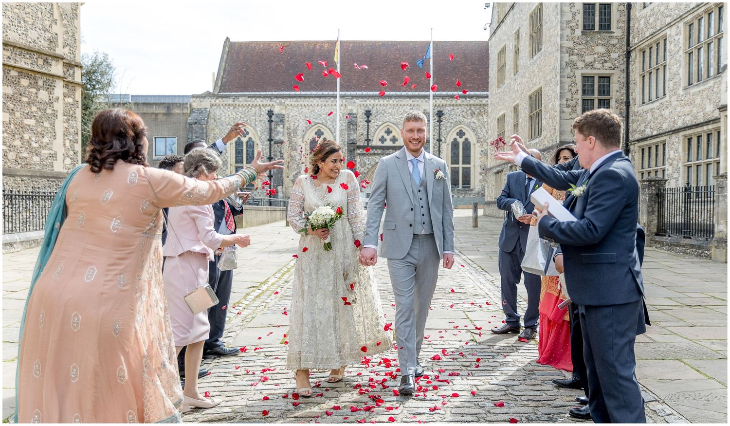 Celebratory moments captured outside historic architecture with wedding guests.