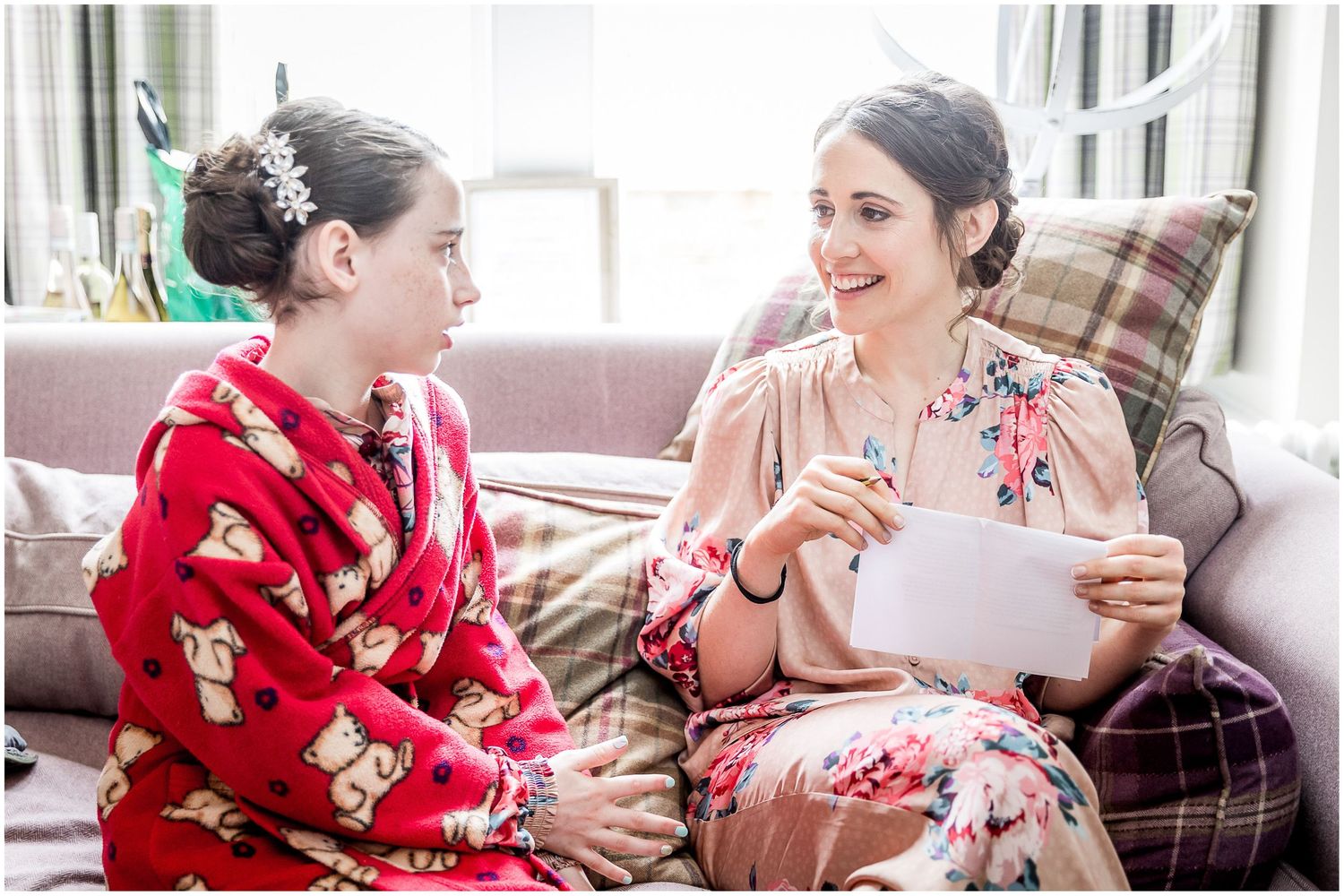 Wedding morning preparations with people in red floral robes relaxing on a couch.