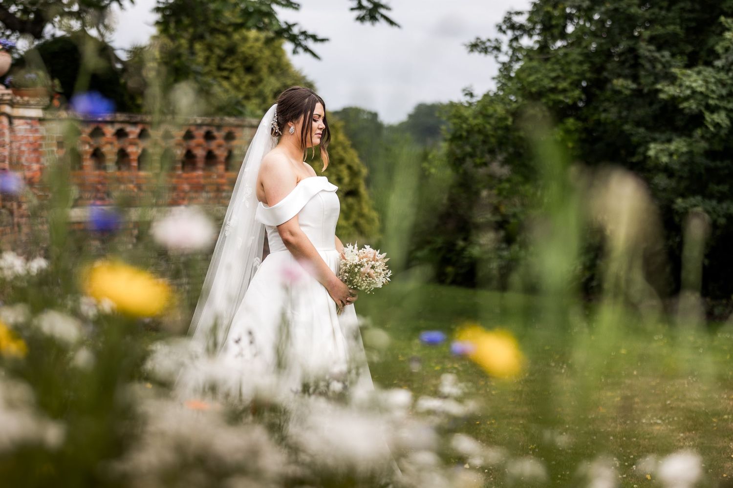 A bride posed amongst flowers for her wedding photography session in the gardens of The Elvetham Hotel
