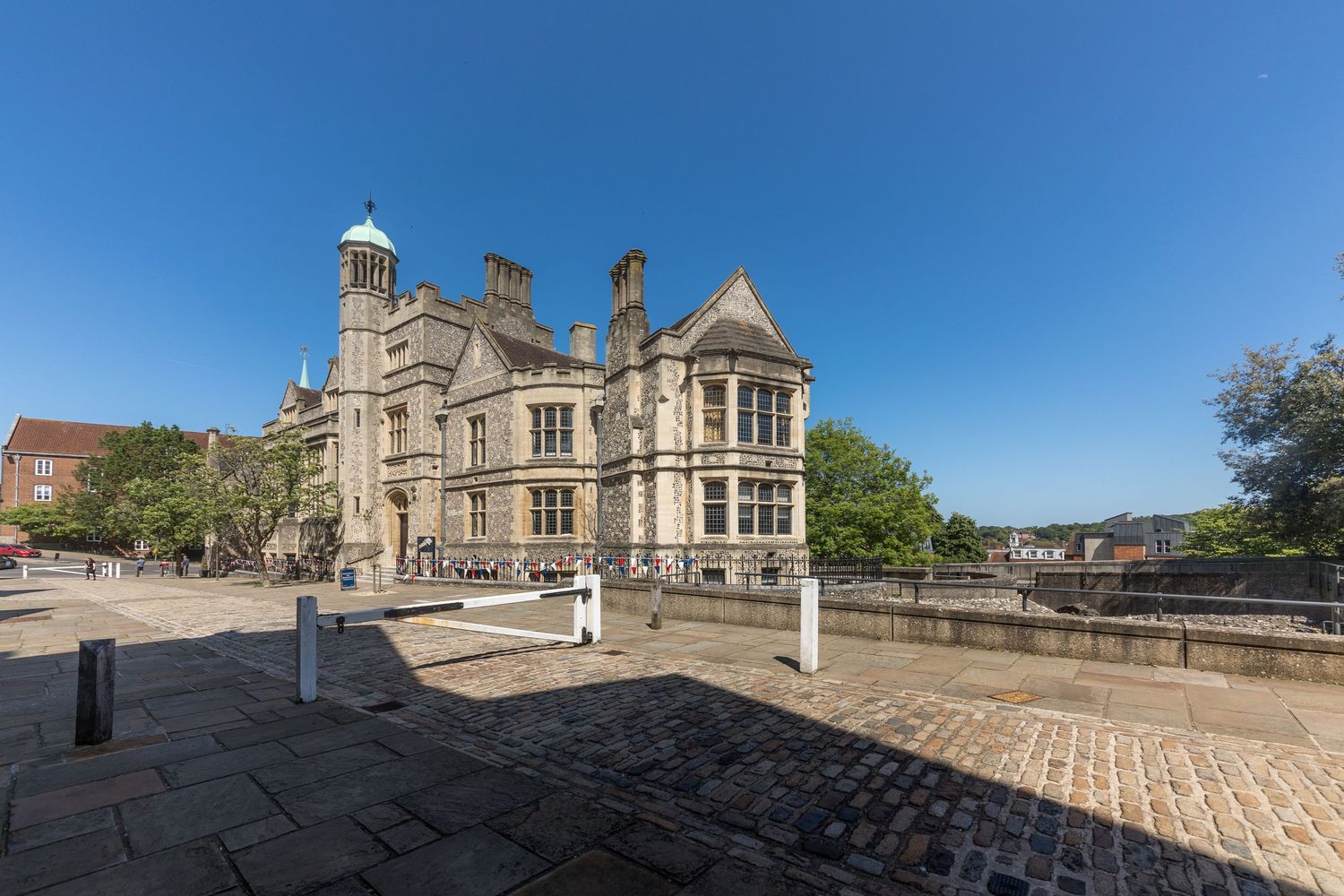 Panoramic view of historic stone architecture and buildings under bright blue sky.
