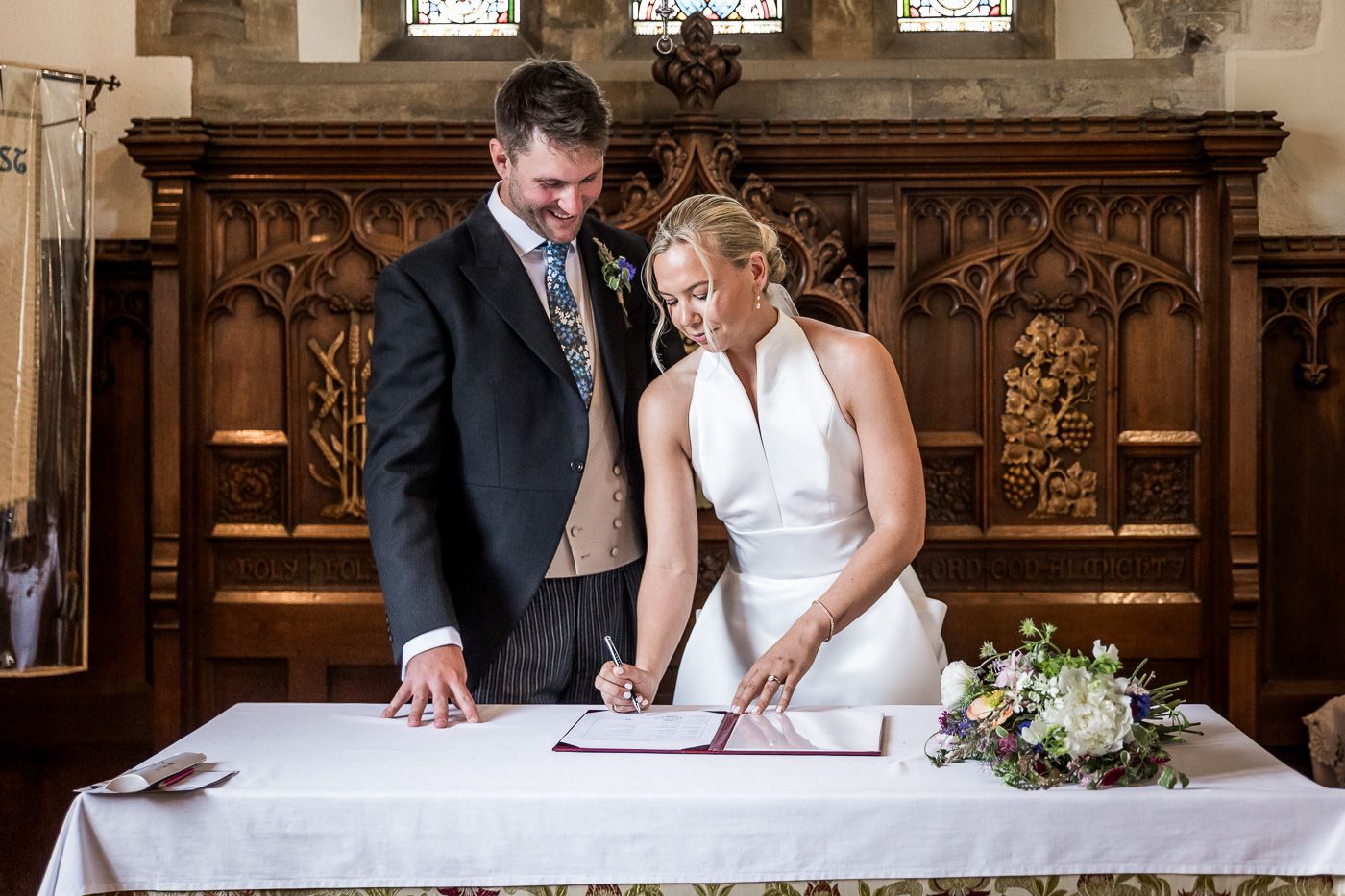 Wedding ceremony in a grand historic church with ornate wooden details.