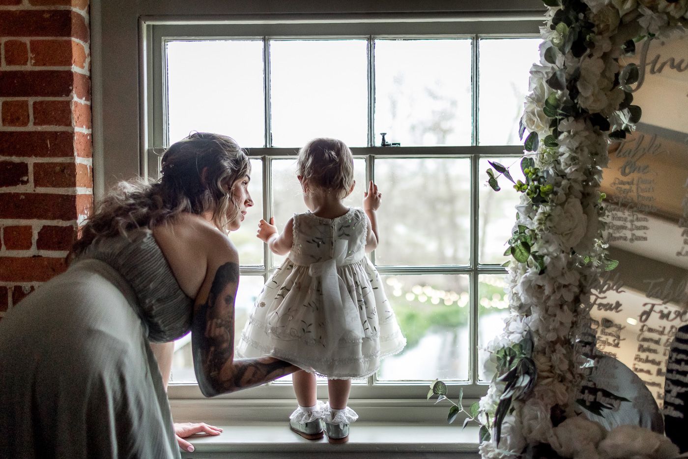 Sunlit bridal preparation room with floral decorations and window light creating a romantic atmosphere.