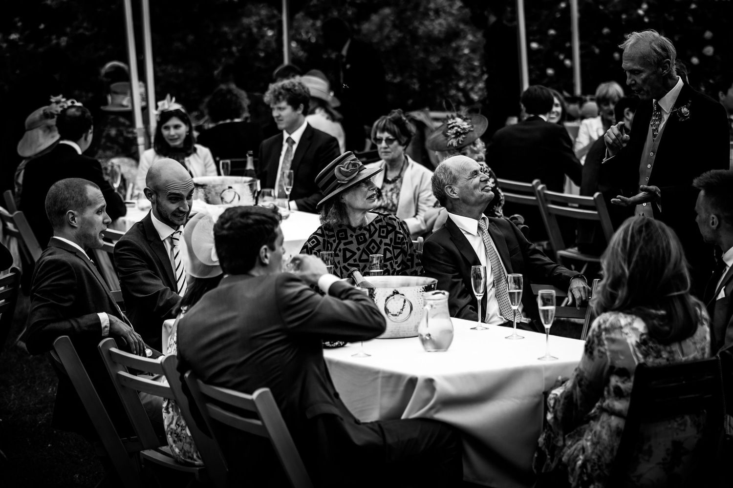 Wedding guests seated in the walled garden at Houghton Lodge for a drinks reception