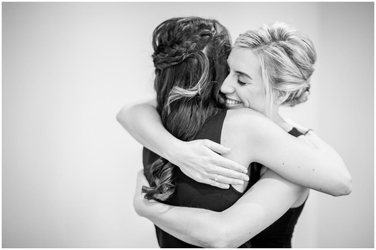 A series of black and white photographs capturing joyful hugs and celebrations at a wedding.