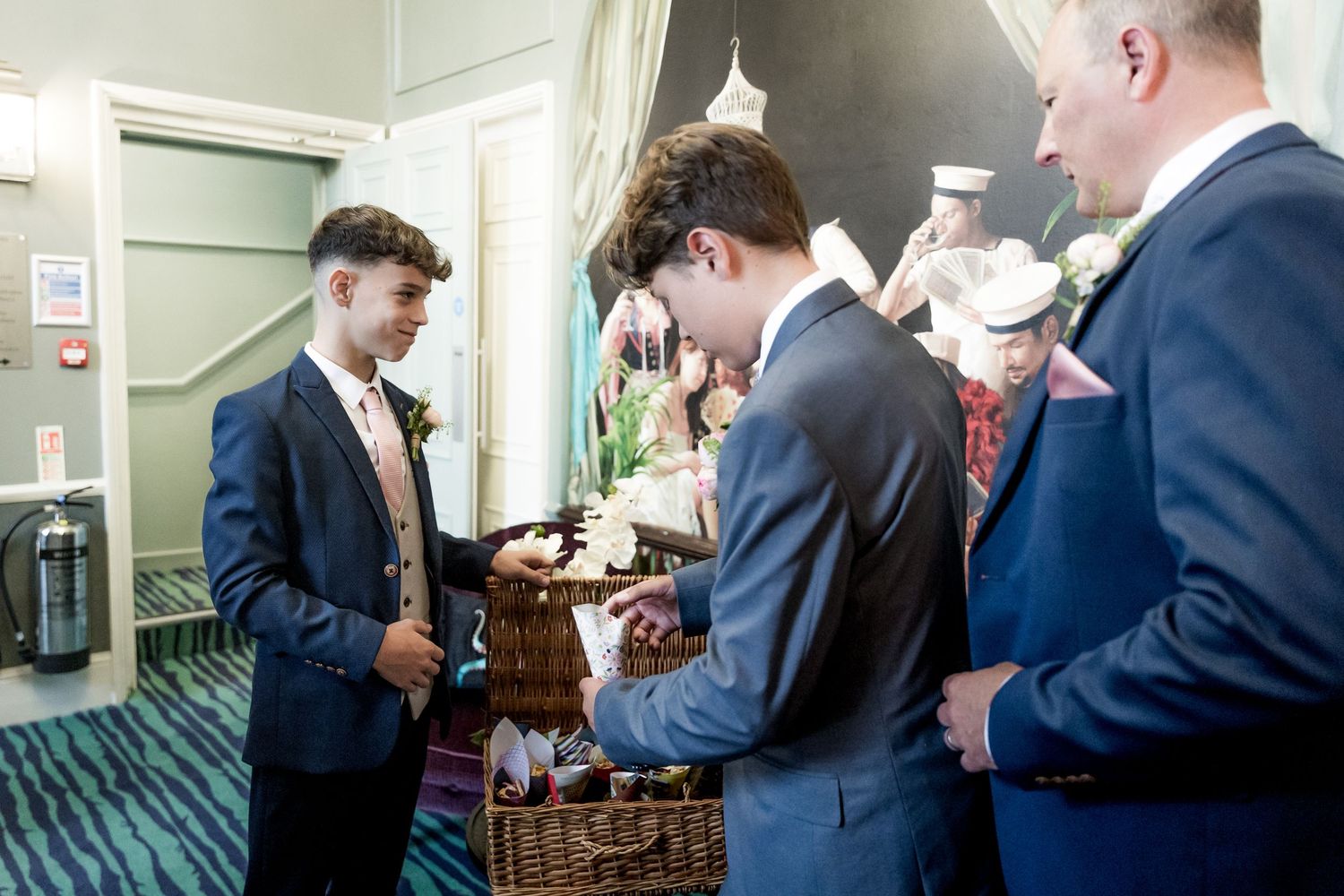 Wedding guests mingling in formal attire at indoor reception.