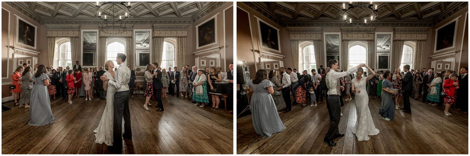 First dance moments captured in a historic ballroom with dramatic lighting and watching guests.