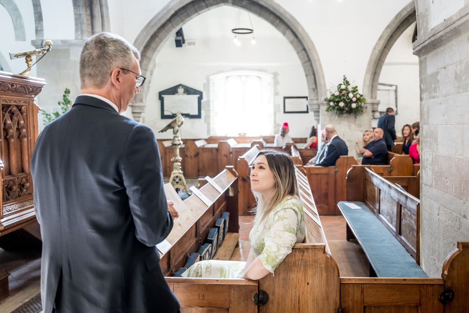 Wedding ceremony taking place inside a traditional stone church with arched ceilings.