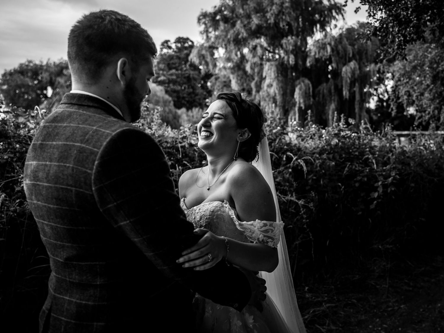 A black and white sequence of candid wedding moments showing laughter and joy during an outdoor ceremony.
