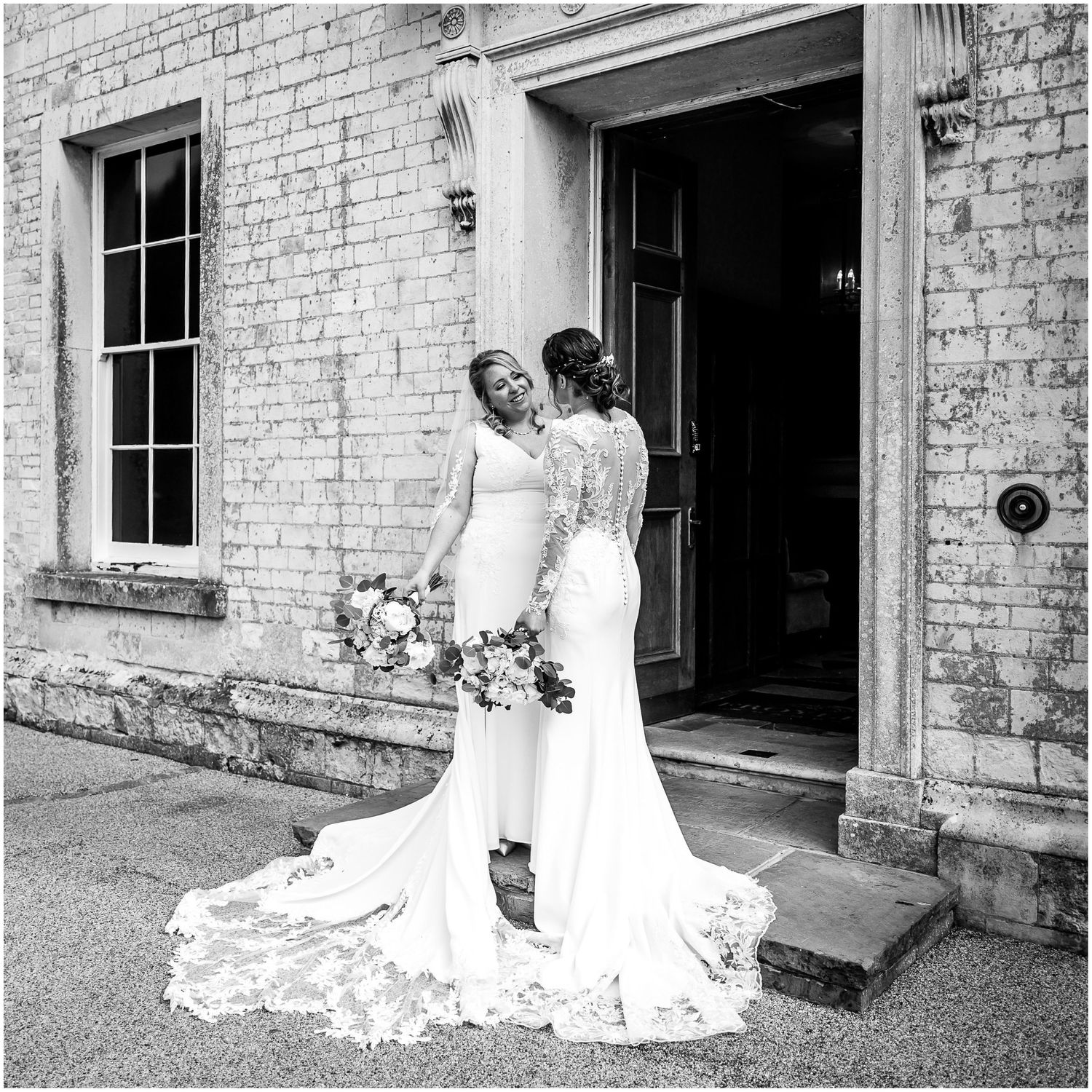 Intimate black and white portraits of couple against historic brick building.