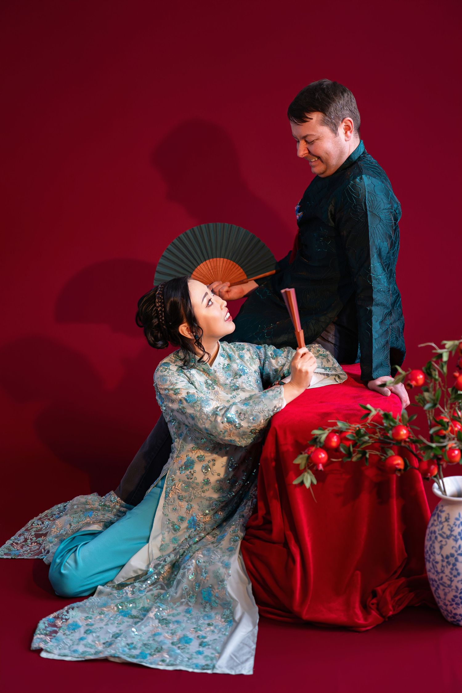 A sequence of artistic photos showing a person in a blue floral dress with a red backdrop and props.