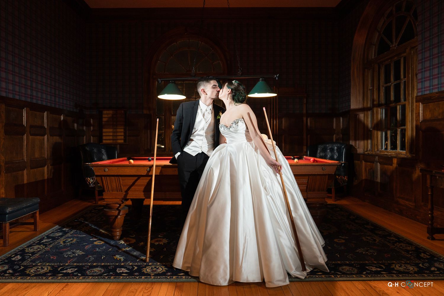 A dramatic wedding portrait on a rainy night with string lights illuminating the scene.