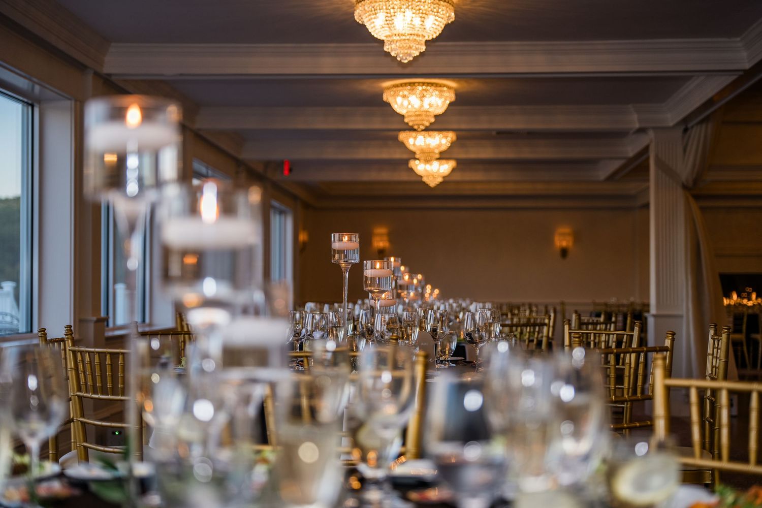 Elegant banquet hall with crystal chandeliers and formal table settings arranged for an upscale dining event.