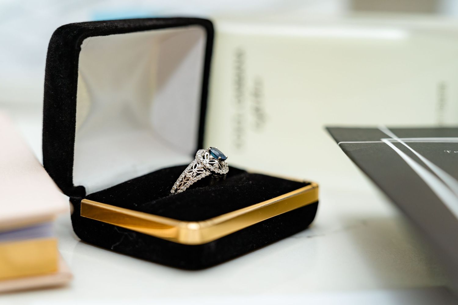 Close-up of an engagement ring in a black velvet box.