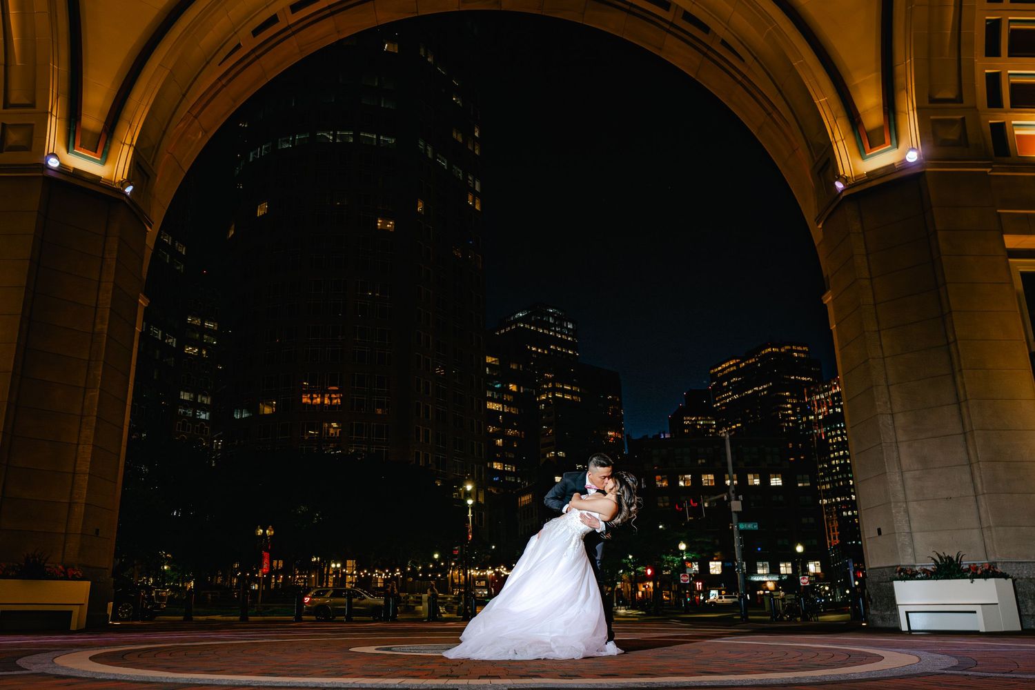 An elegant archway frames a nighttime cityscape with twinkling lights.
