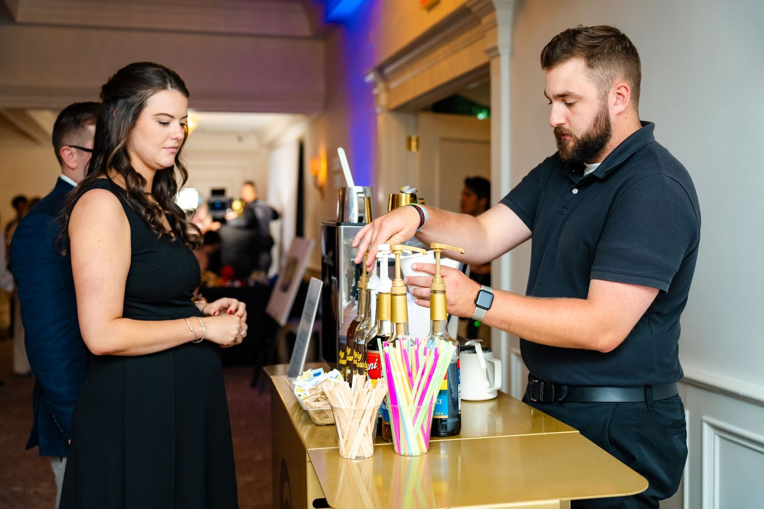 Bartender pours drinks at elegant wedding reception bar.