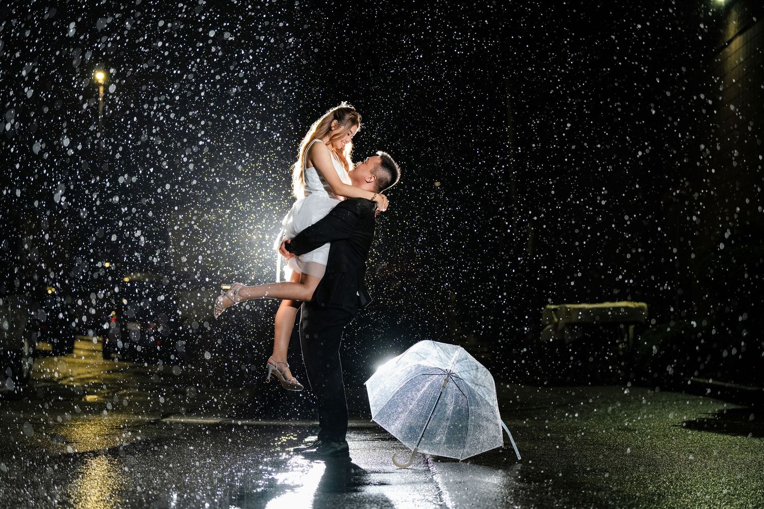 Dancing couple silhouetted against falling snow at night creating a magical winter wedding scene.