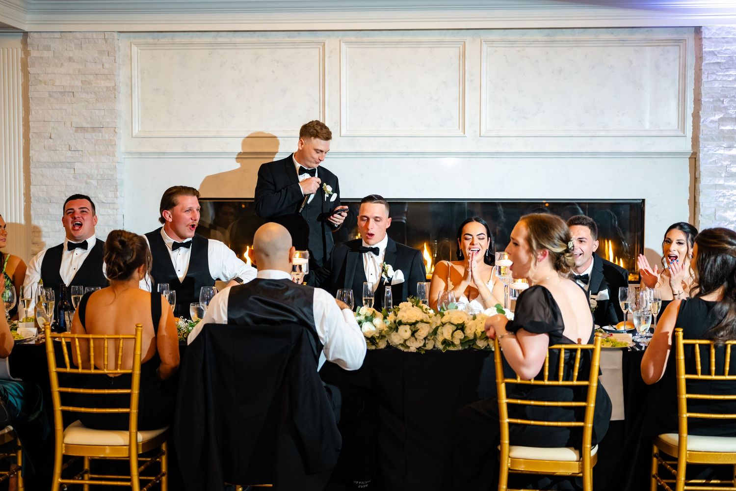 Wedding reception ballroom with gold chairs and ambient lighting creating a romantic atmosphere.