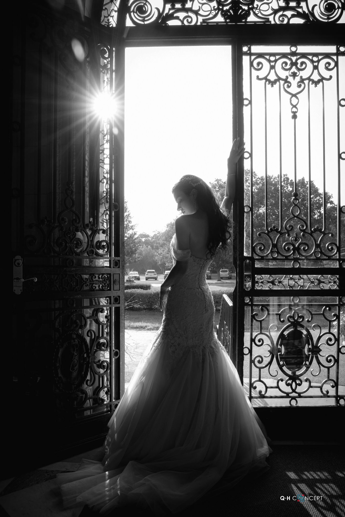 Artistic black and white silhouettes through ornate iron gates with dramatic lighting.