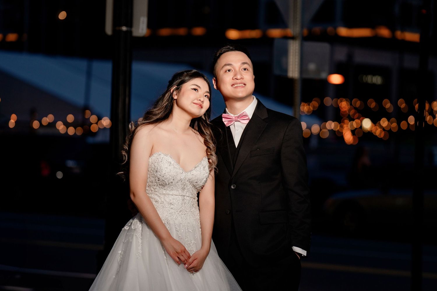 Evening wedding photos with city lights twinkling in the background.
