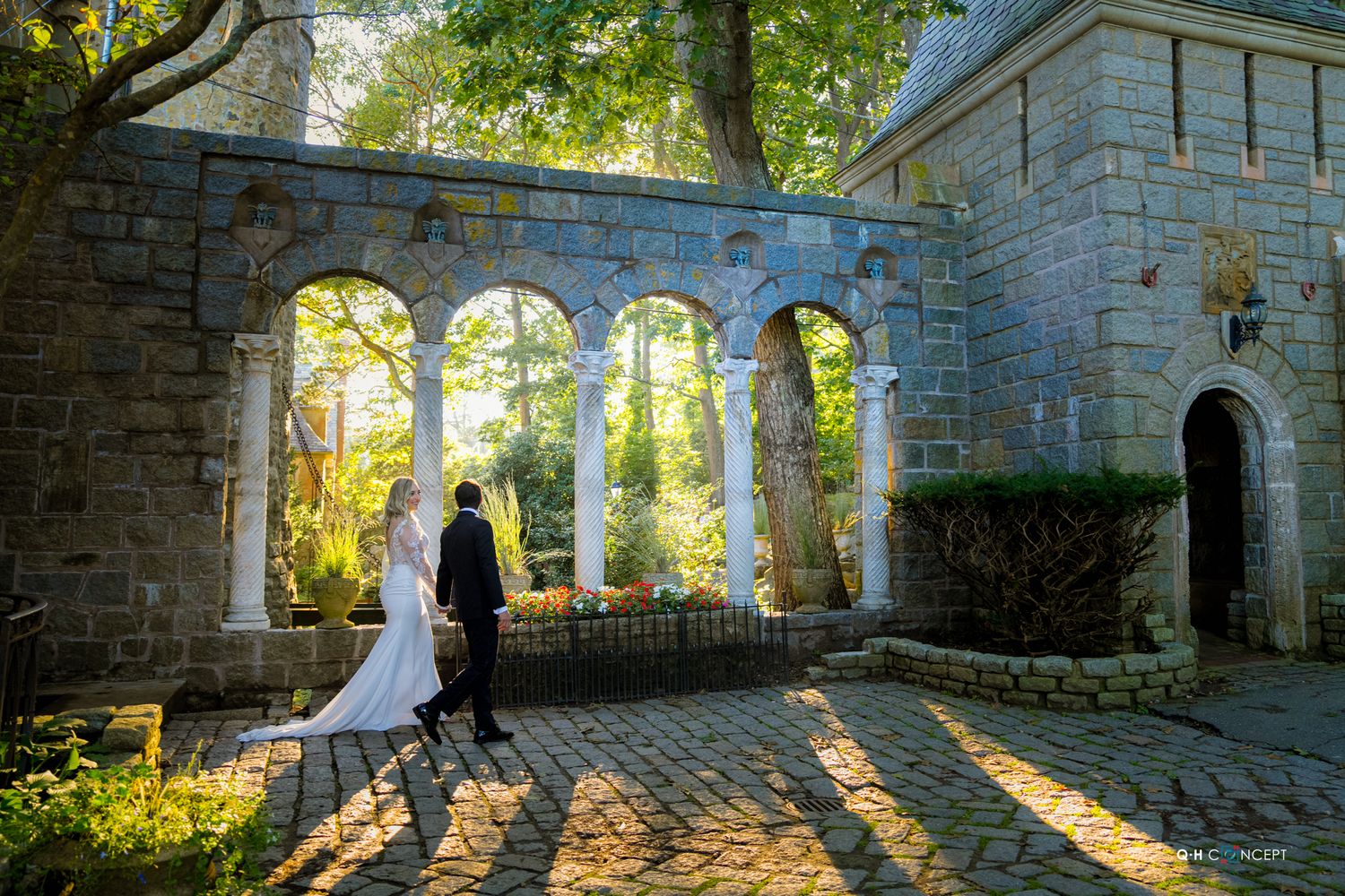 Wedding portraits taken in a stone courtyard with beautiful natural sunlight streaming through arches.