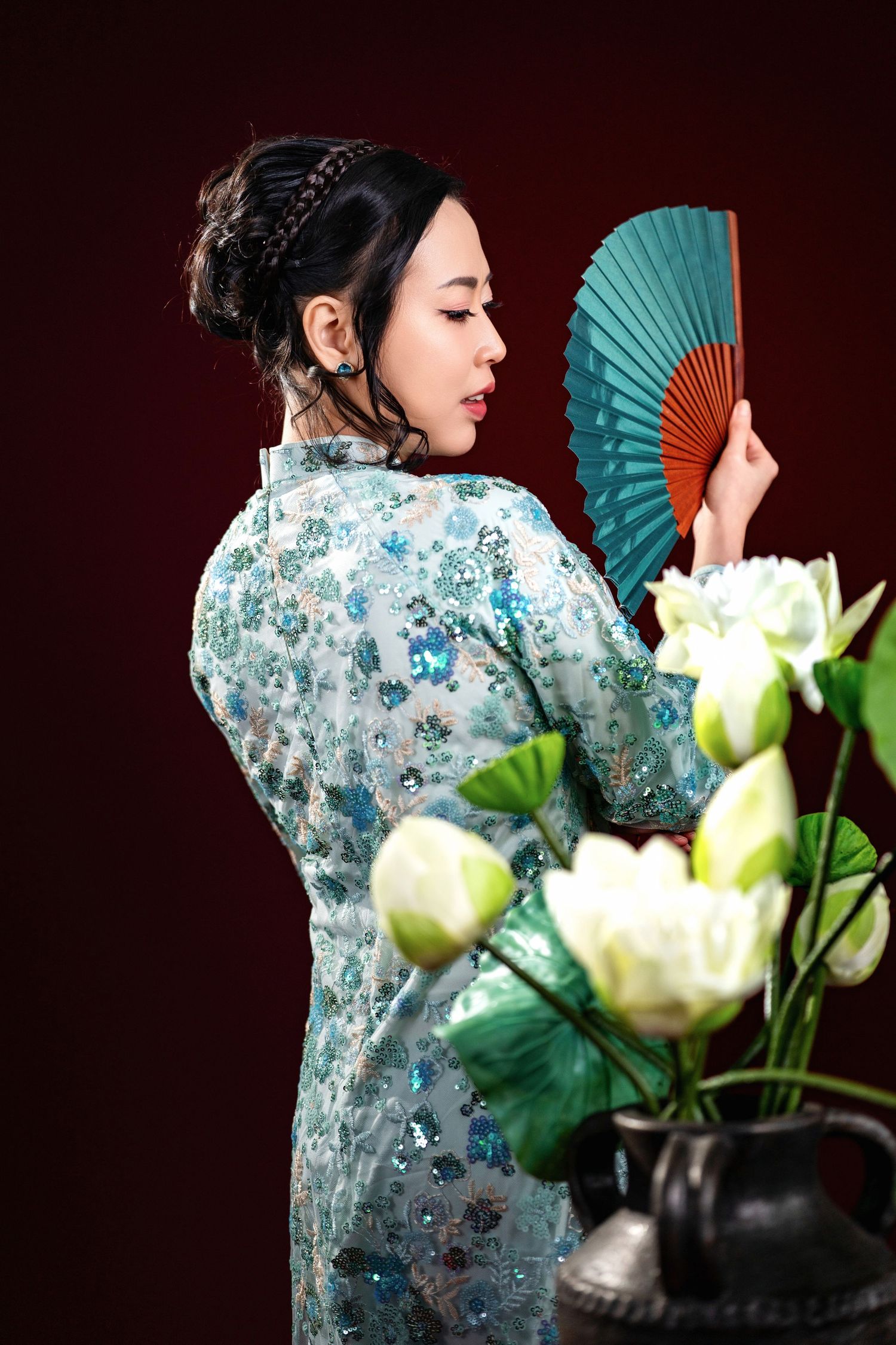 A series of artistic photos showing traditional Asian fan dance poses against a dark background with white lotus flowers.