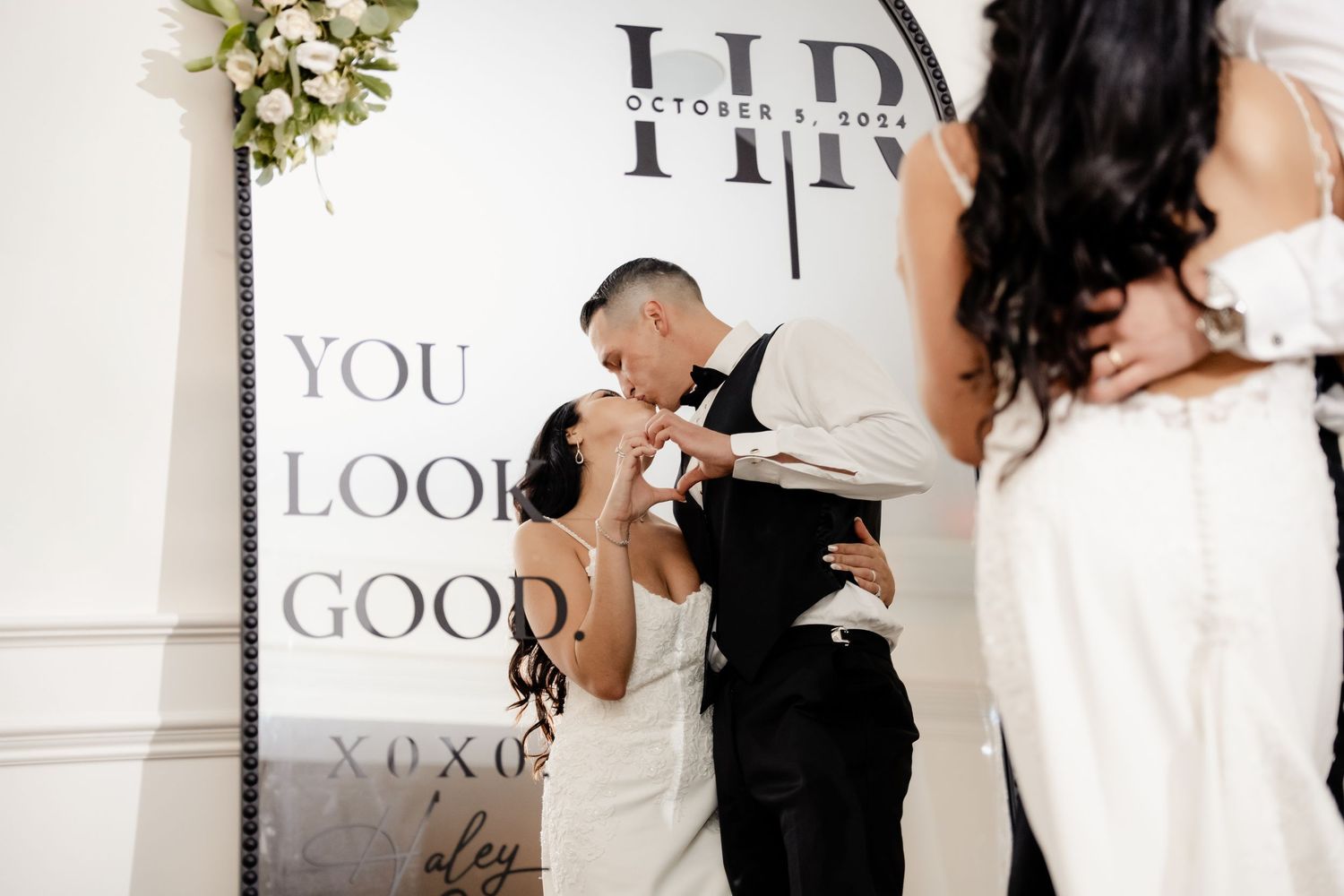 Dancers move gracefully across a bright reception hall with elegant decor and signage.
