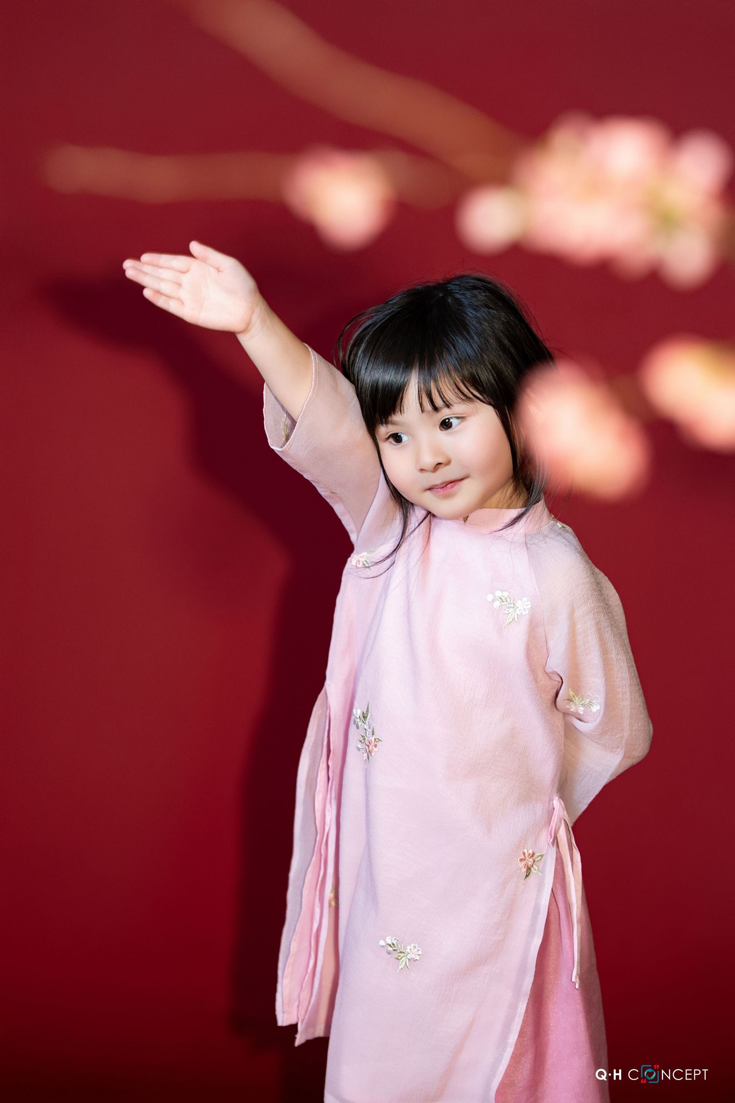 Series of graceful dance poses in pink traditional dress against a red backdrop with soft lighting effects.