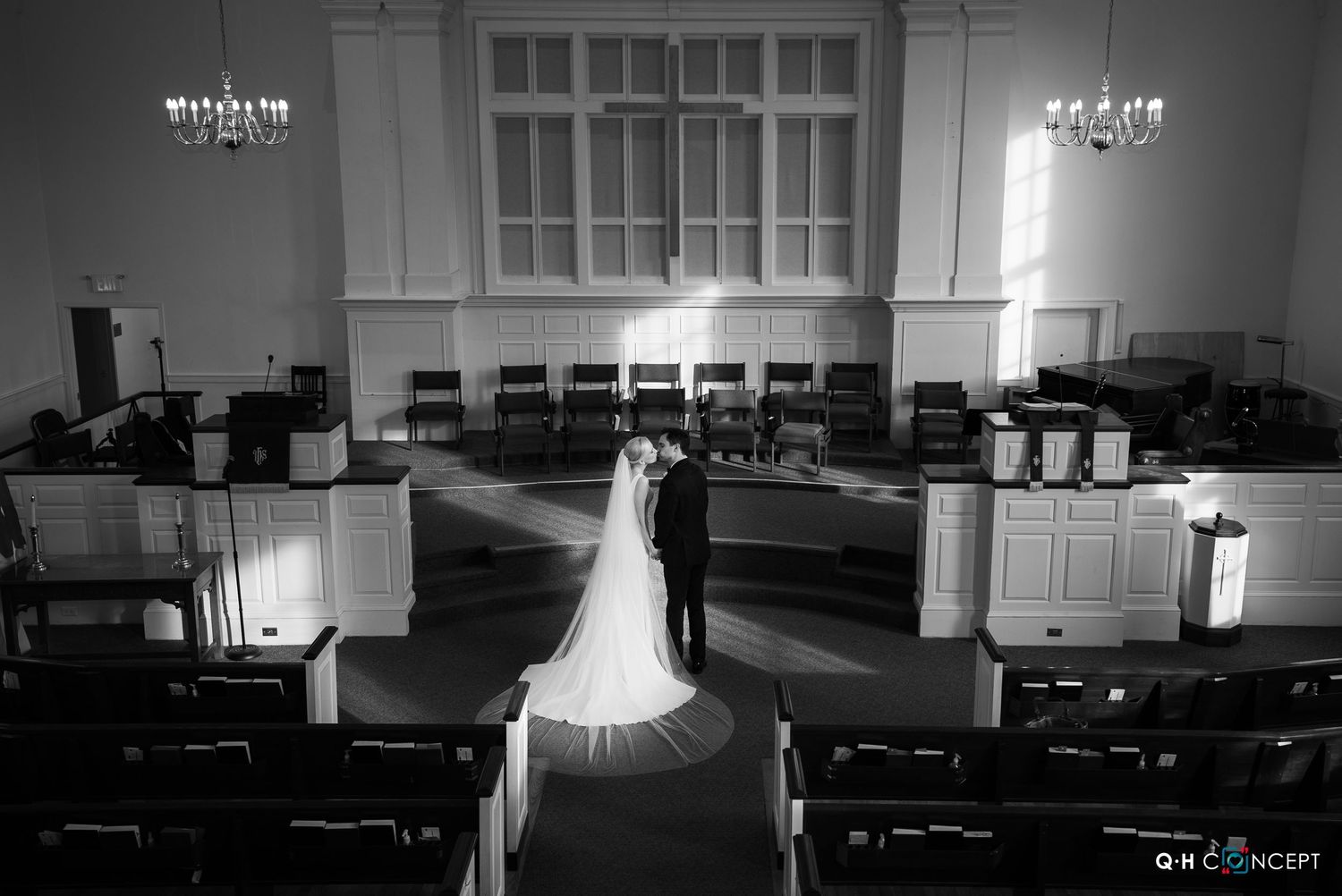 Minimalist black and white wedding dress detail in an empty church interior.