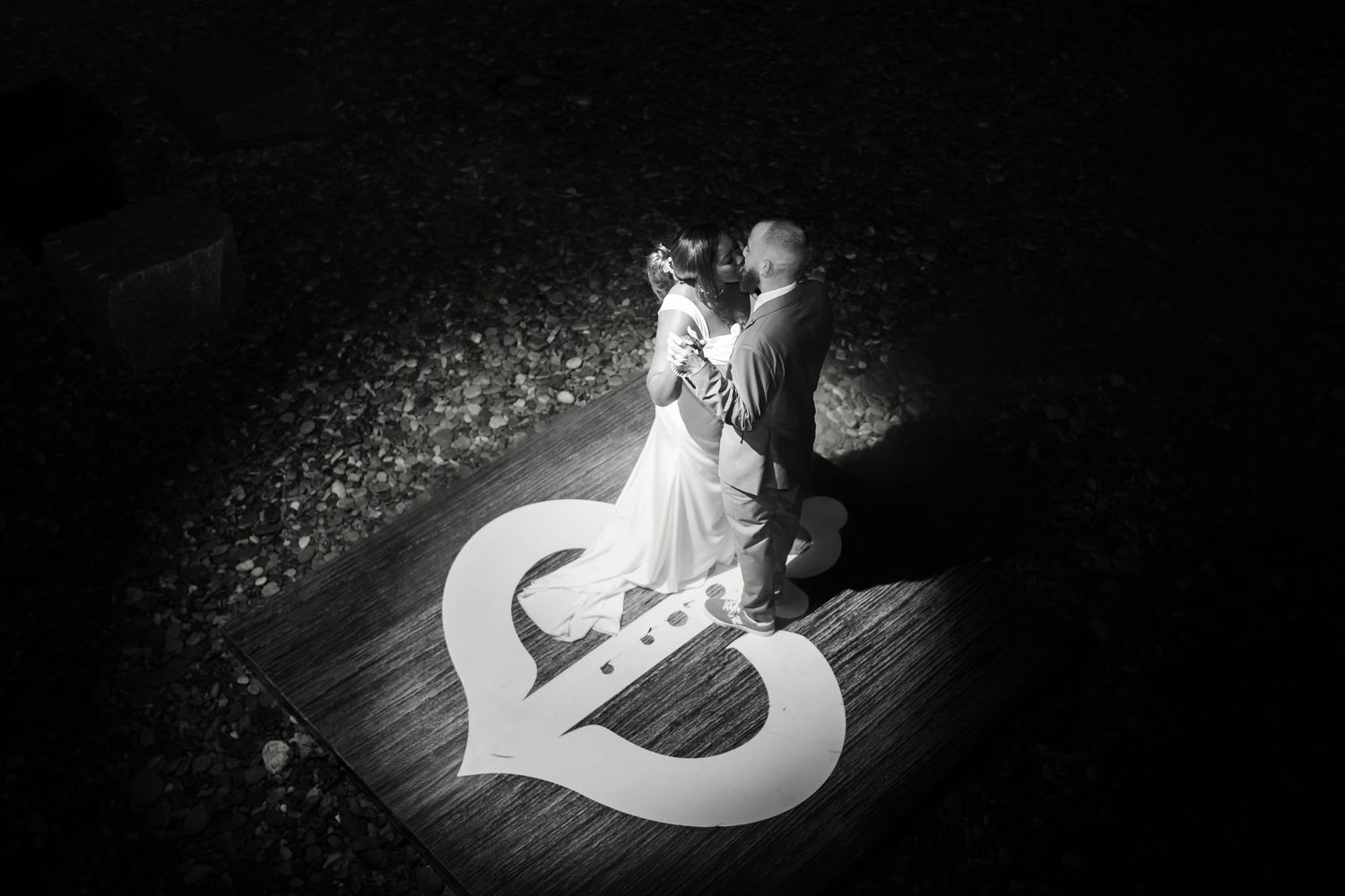 Dramatic black and white spotlight dance photos at a wedding reception.