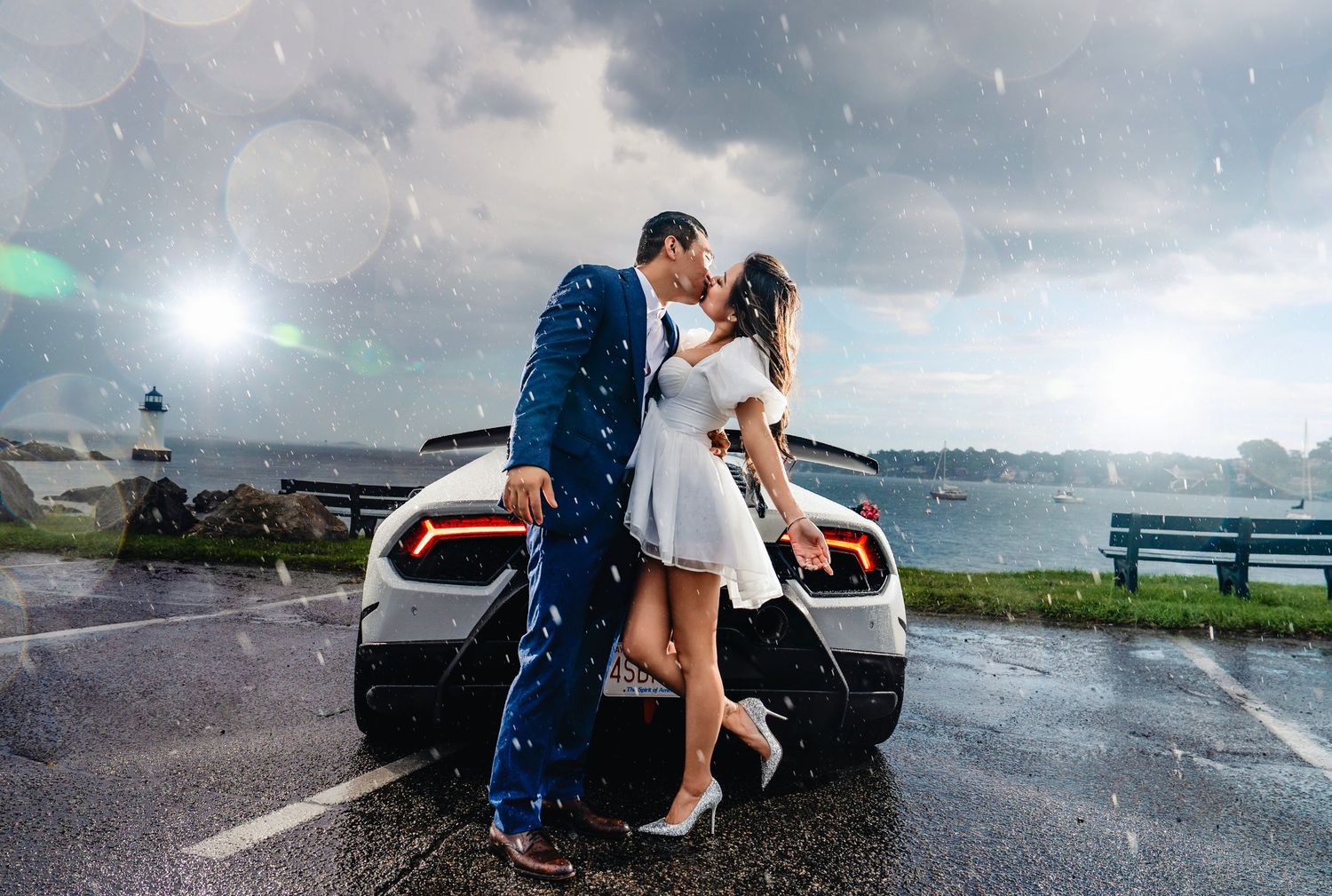 A romantic moment captured in the rain next to a parked car with stormy skies overhead.