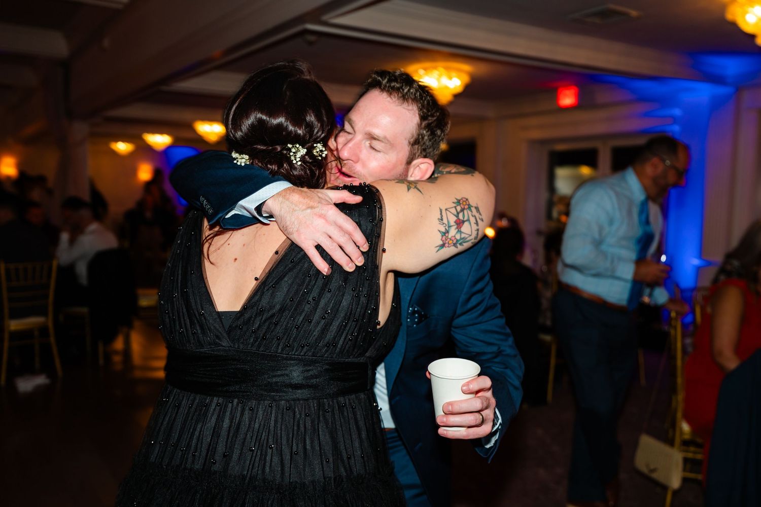 Wedding reception dance floor with guests enjoying the celebration under warm lighting.