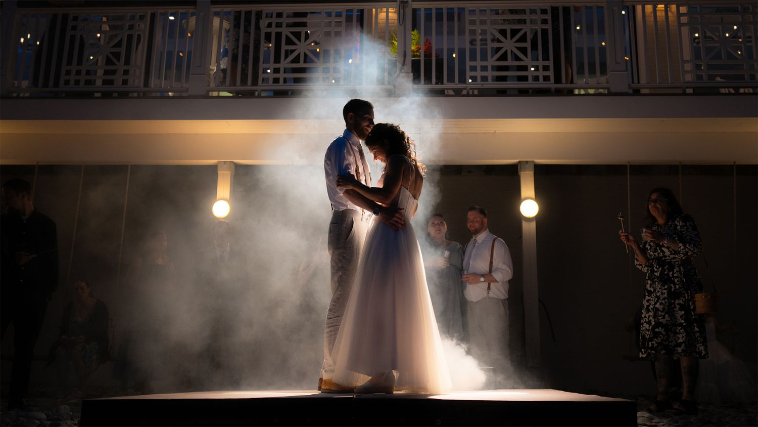 A silhouetted couple shares a romantic moment in dramatic lighting during their wedding photoshoot.