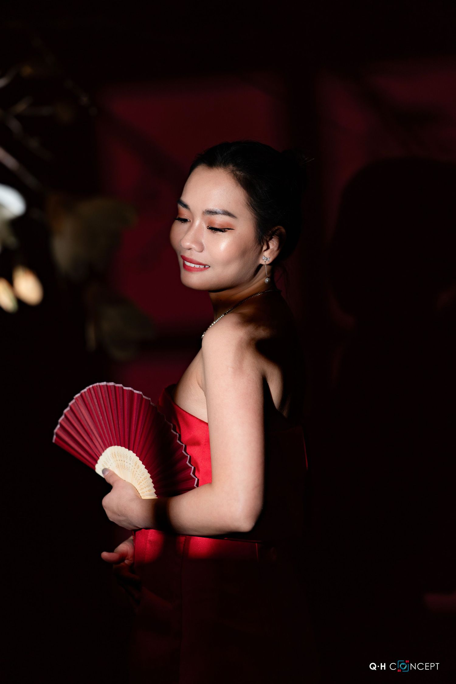 Dramatic low-key portraits with red paper fan and dark shadows creating an intimate artistic atmosphere.