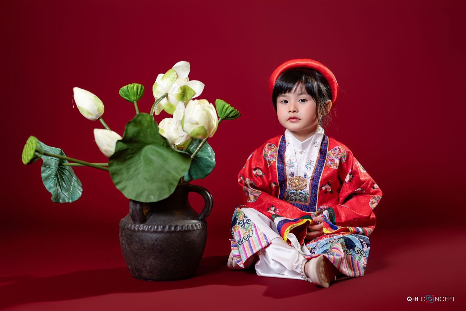A series of traditional Japanese style photos with white lotus flowers and red decor against a deep burgundy background.
