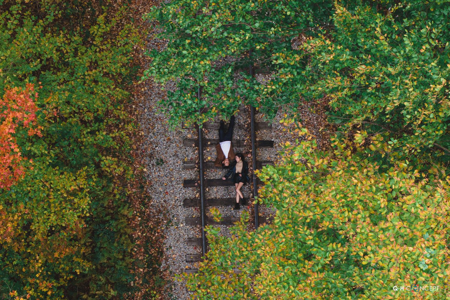A romantic photoshoot in a lush garden setting with colorful autumn trees.