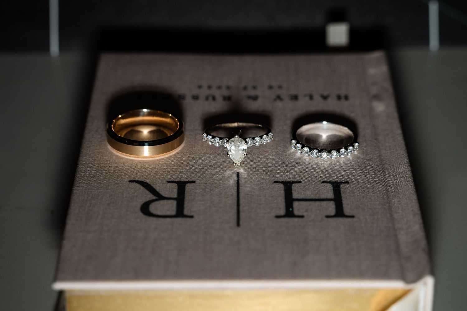 Wedding rings displayed on a light colored surface with elegant text in the background.