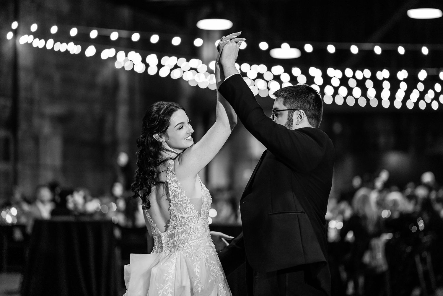 Wedding celebration under twinkling lights at an evening reception.
