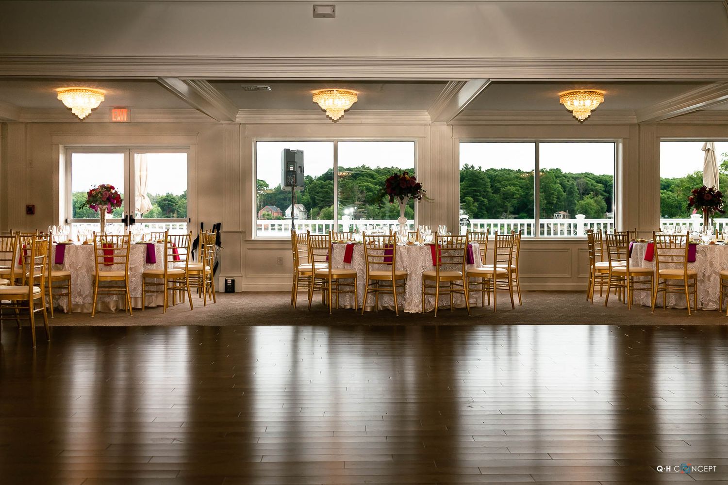 Spacious reception hall with dark hardwood floors and large windows offering natural light for special occasions.