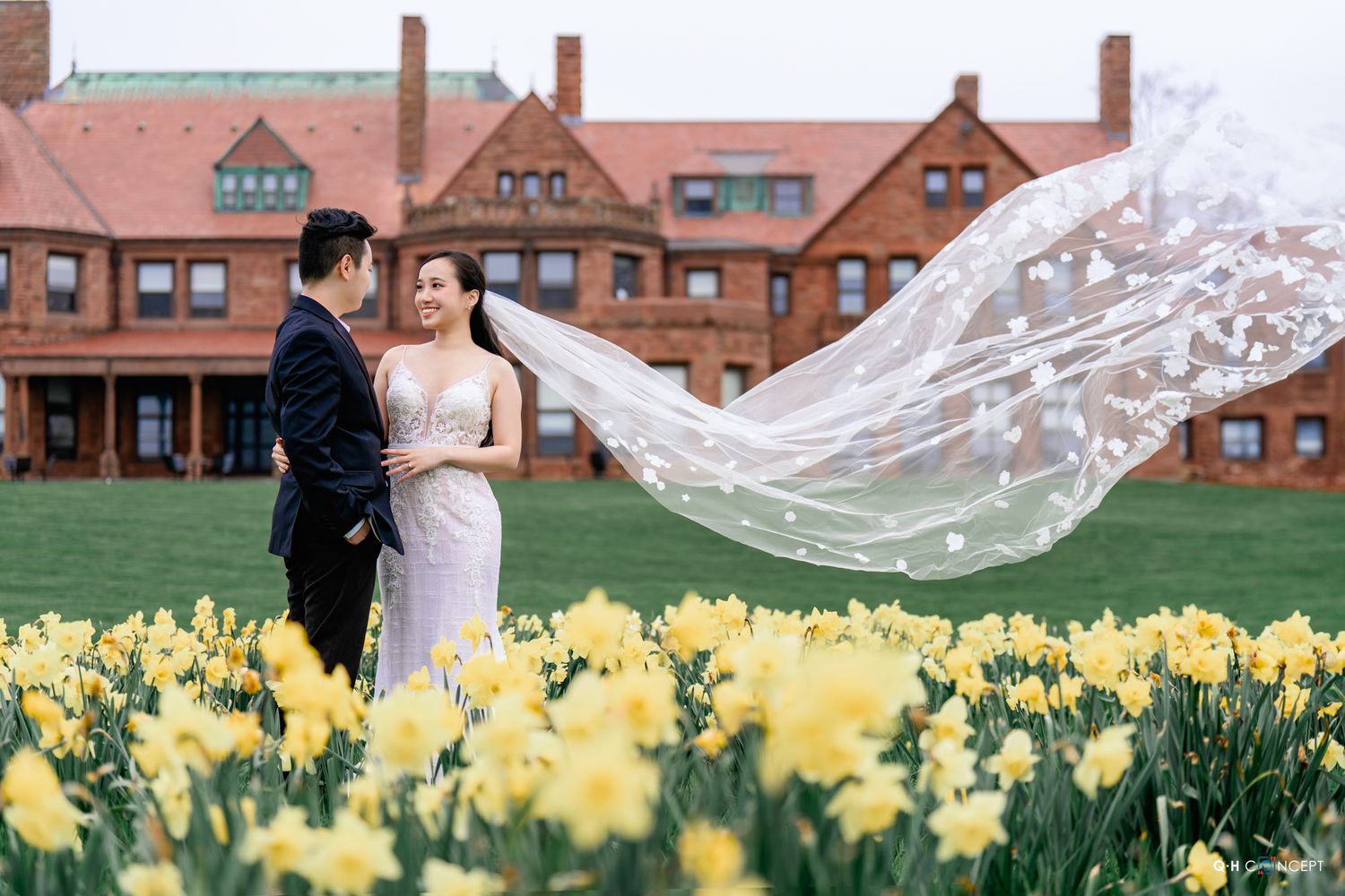 Wedding photos captured in front of historic brick buildings with flowing veil and yellow daffodils.