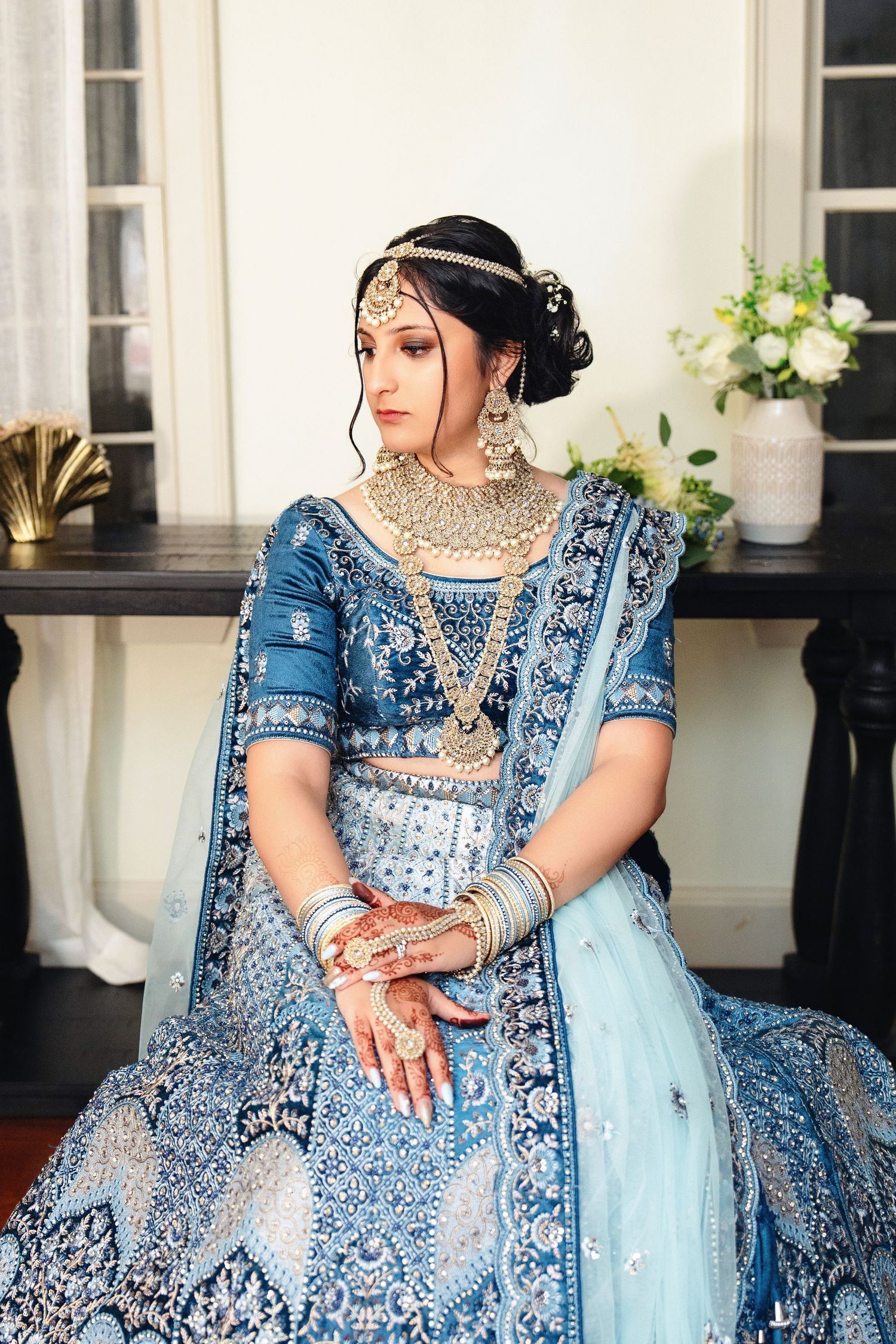 Detailed shots of an ornate blue and silver traditional Indian bridal lehenga with intricate embroidery.