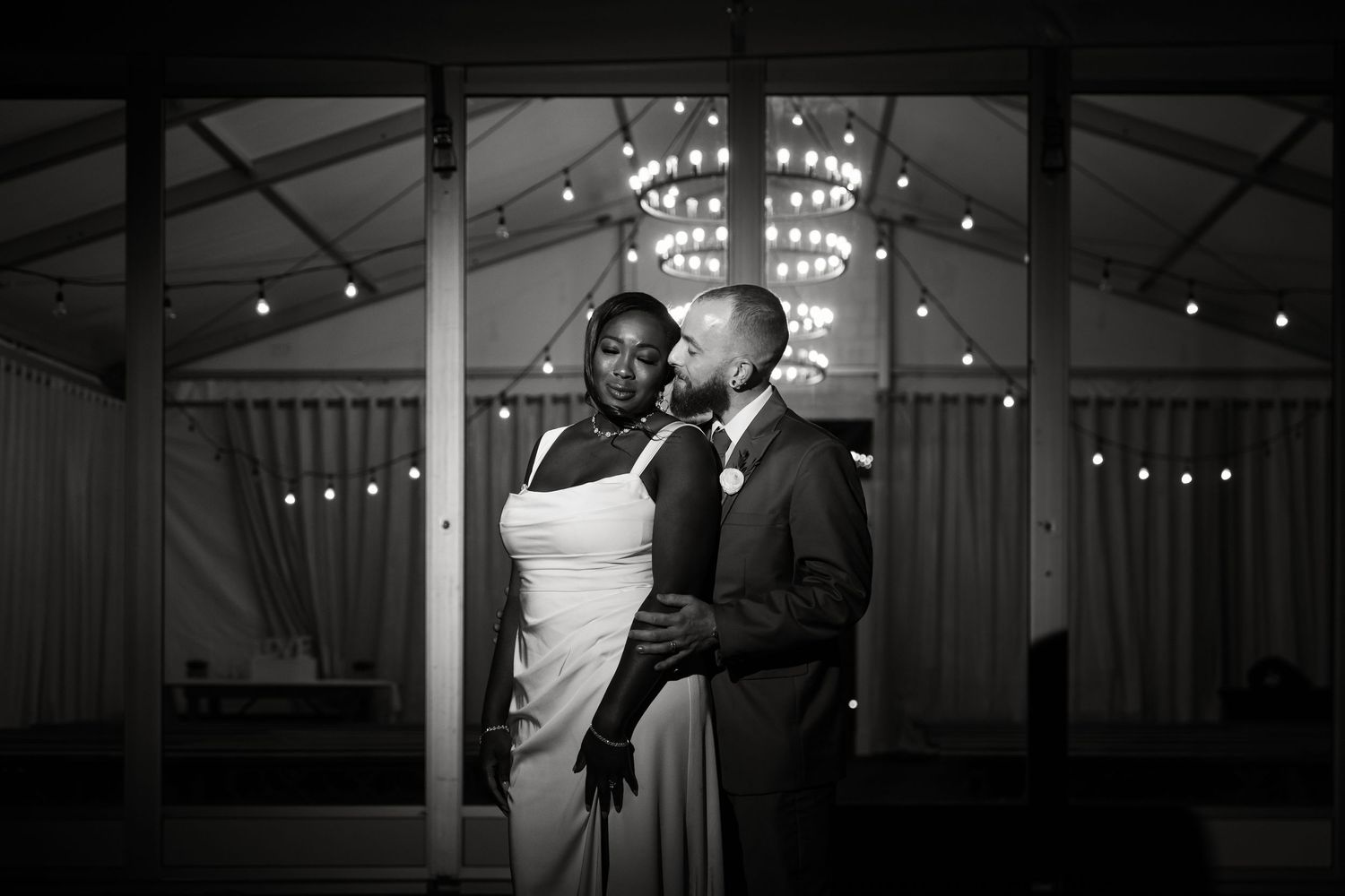 Indoor wedding venue with elegant lighting and dark silhouettes of dancing figures.