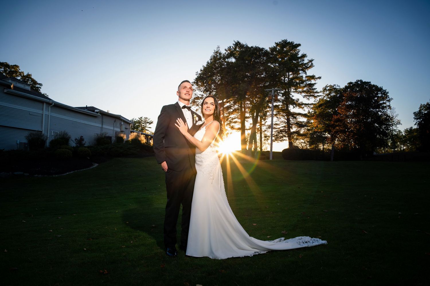 Golden sunset wedding photos captured on sprawling green lawn.