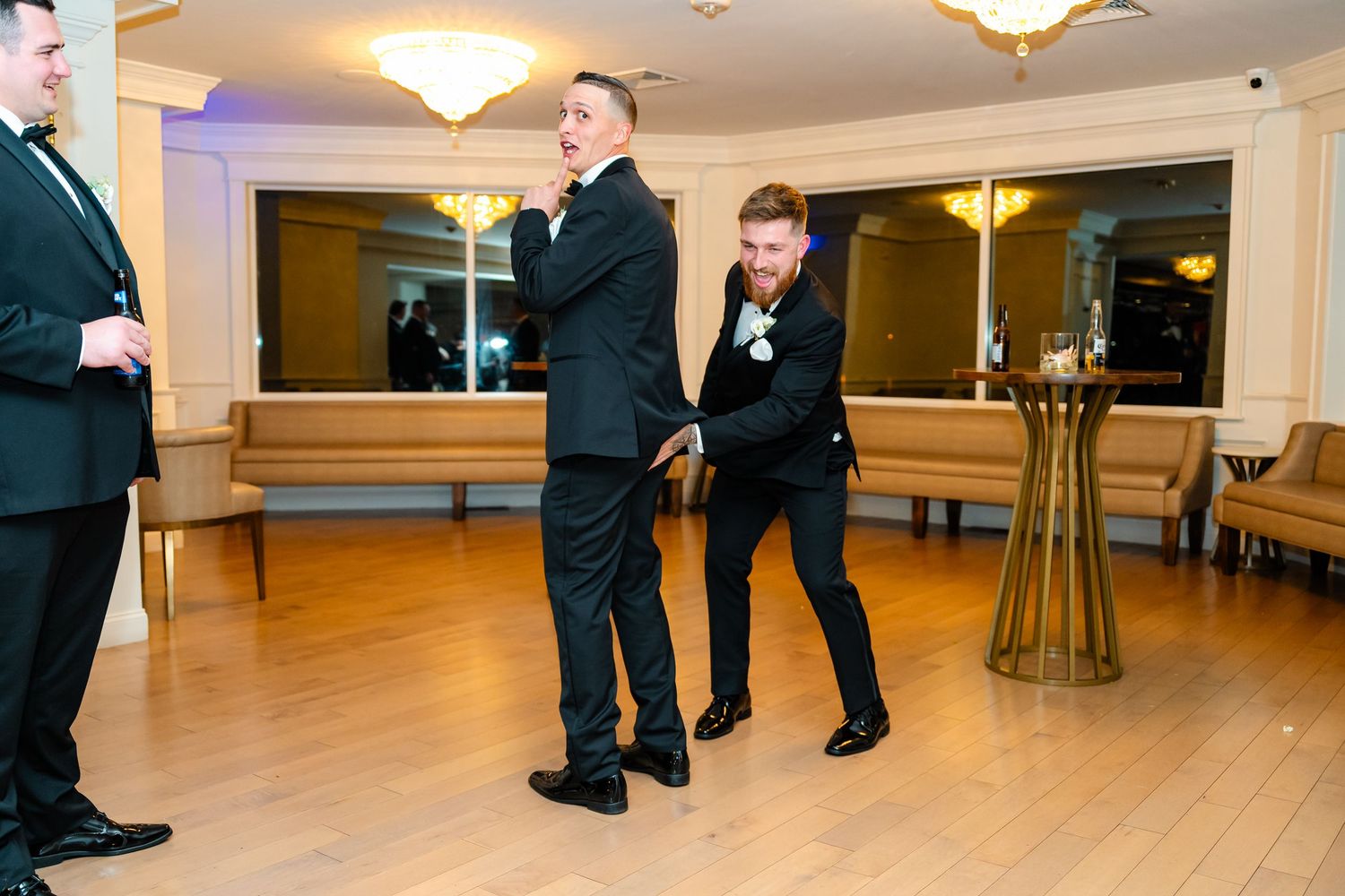 Low angle view of wedding reception venue with hardwood floors and formal attire.
