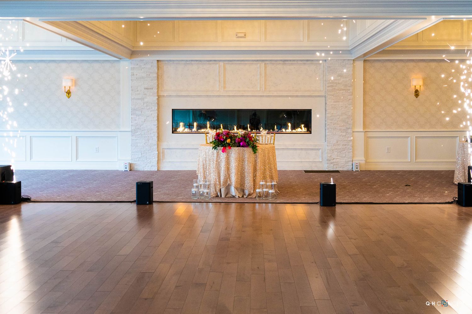 Elegant ballroom venue with hardwood floors, white wainscoting, and crystal chandeliers perfect for wedding receptions.