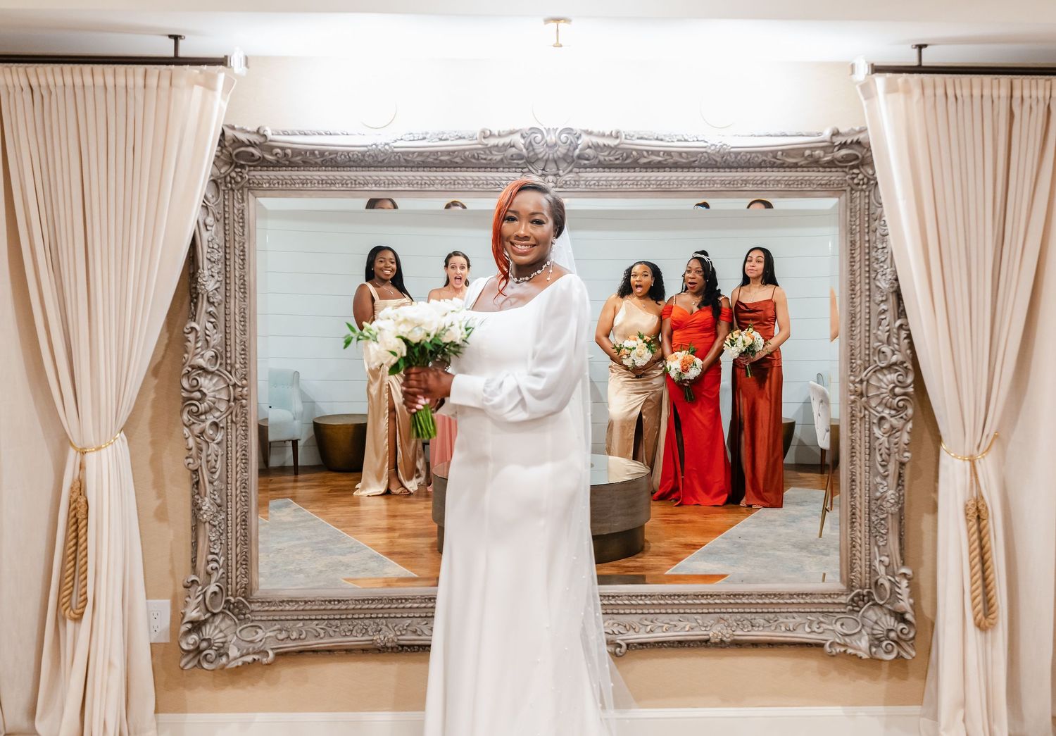 Wedding venue interior with elegant curtains, ornate frames, and floral arrangements.